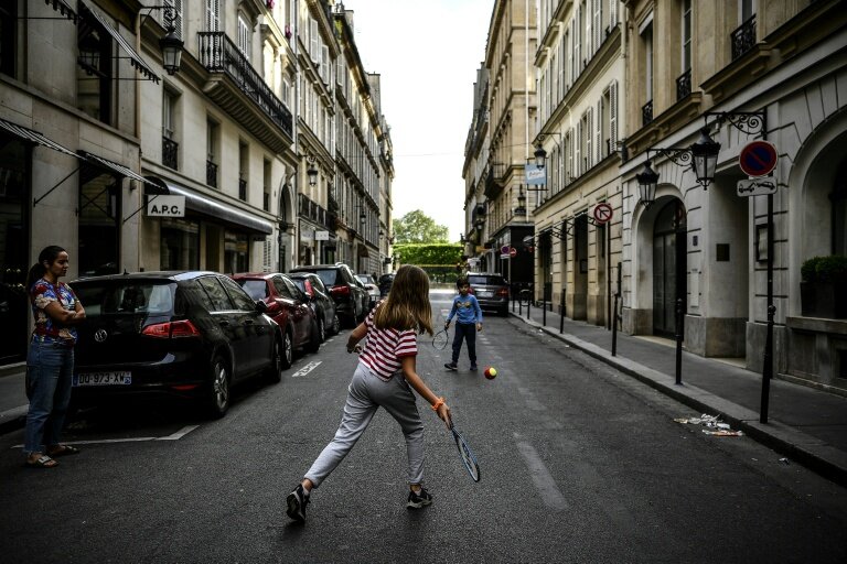 Des enfants jouent au tennis dans une rue de Paris le 21 avril 2020, en plein confinement lié au Covid-19 © Christophe ARCHAMBAULT