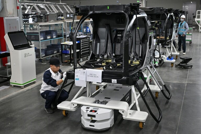 Des employés travaillent sur une chaîne de montage pour la voiture volante électrique "Land Aircraft Carrier" dans une usine de la filiale Aridge de Xpeng à Guangzhou, dans le sud de la Chine, le 6 novembre 2025 © Jade GAO