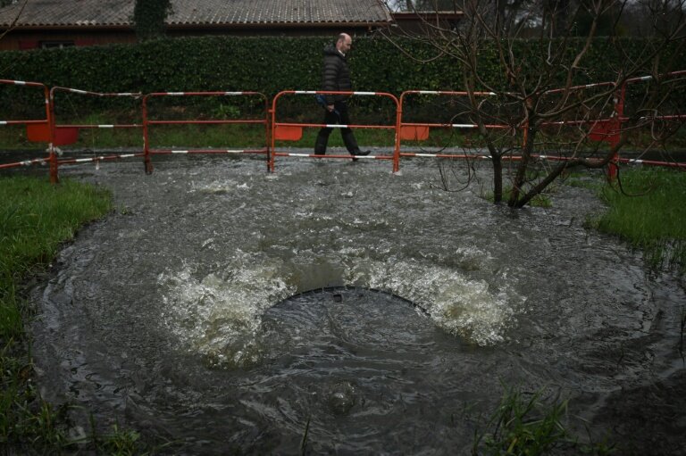 Un habitant passe devant une bouche d'égout débordant d'eaux usées non traitées près de la station de pompage de Taussat à Lanton, dans le bassin d'Arcachon, le 5 février 2026 en Gironde © Philippe LOPEZ