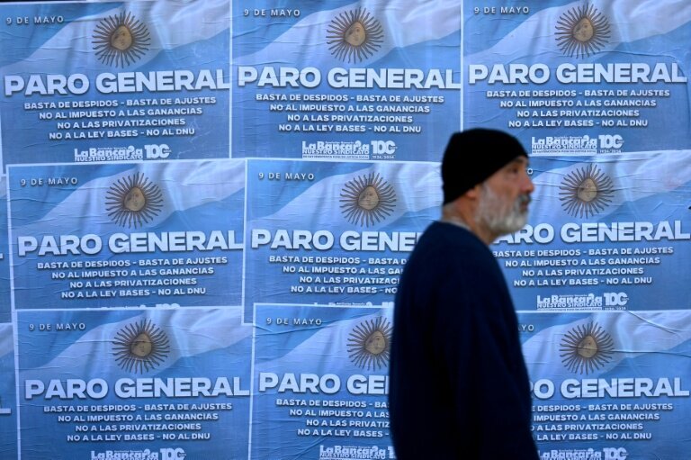 Un homme passe devant des affiches appelant à la grève générale le 9 mai 2024 à Buenos Aires, la deuxième depuis le début du mandat du président argentin Javier Milei © Luis ROBAYO