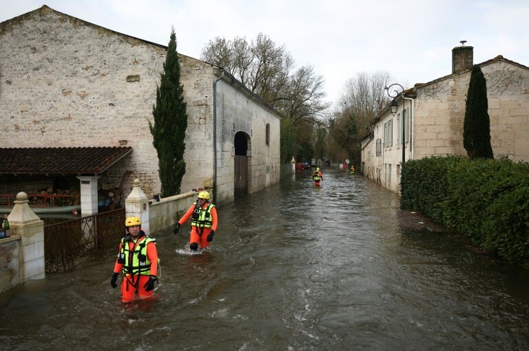 Des sauveteurs en mer dans une rue inondée lors d'une opération visant à évacuer des habitants isolés à Courcoury, en Charente-Maritime, le 21 février 2026 © ROMAIN PERROCHEAU