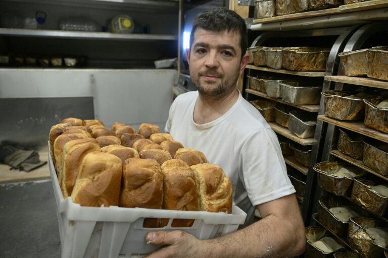 Le boulanger bénévole français Loïc Nervi tient un panier de pain fraîchement cuit dans sa boulangerie mobile afin de le distribuer aux résidents d'un logement temporaire pour les personnes qui ont perdu leur maison et les personnes déplacées à Borodianka, dans la région de Kiev, le 19 février 2026, dans le contexte de l'invasion russe de l'Ukraine. © Genya SAVILOV