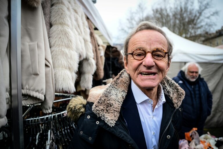 Alain Carignon, ancien ministre et ancien maire de Grenoble, candidat tête de liste des Républicains à la mairie de Grenoble, distribue des tracts de campagne sur un marché, le 7 février 2026 à Grenoble © OLIVIER CHASSIGNOLE