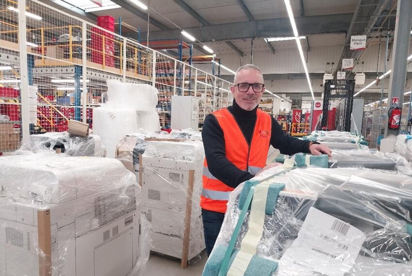 Pascal Ferrari, responsable du développement chez Distri3R pose devant des copieurs reconditionnés.