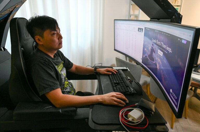 Mark Koh, un investisseur singapourien spécialisé dans les cryptomonnaies et victime d'une escroquerie, devant son écran d'ordinateur lors d'un entretien avec l'AFP chez lui à Singapour, le 30 janvier 2026 © Roslan RAHMAN