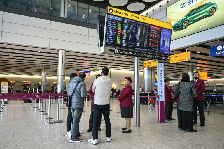 Des passagers devant le comptoir d'enregistrement fermé de la compagnie aérienne Qatar Airways, le 1er mars 2026 à l'aéroport Heathrow de Londres © JUSTIN TALLIS