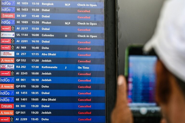 Un passager prend une photo d'un tableau d'affichage des vols annulés vers les destinations du Moyen-Orient à l'aéroport international de Bombay le 1er mars 2026 en Inde © Punit PARANJPE