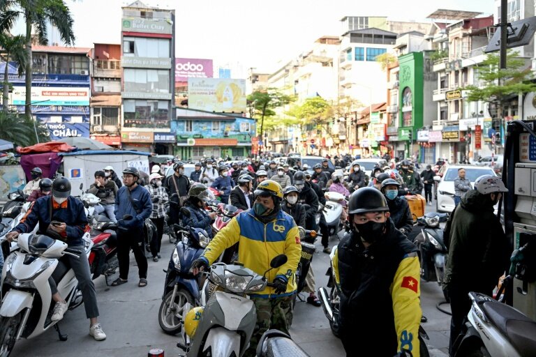 Des motocyclistes font la queue pour faire le plein d'essence dans une station-service à Hanoï, le 10 mars 2026 au Vietnam © Nhac NGUYEN