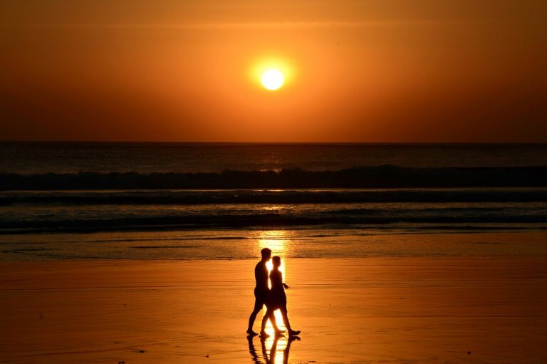 Des promeneurs sur la plage de Kuta beach à Bali, près de Denpasar © SONNY TUMBELAKA