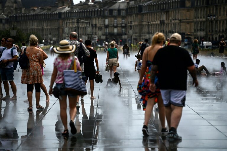 Des passants se rafraîchissent sur le Miroir d'Eau à Bordeaux, le 23 août 2023 pendant une vague de chaleur en France © Christophe ARCHAMBAULT