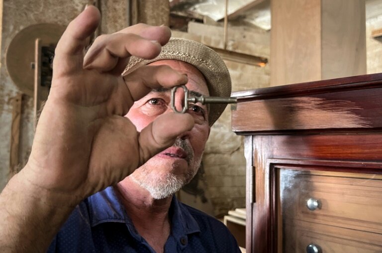 L'artisan René Reyes vérifie la clé d'une cave à cigares dans son atelier de La Havane, le 5 septembre 2023 à Cuba © ADALBERTO ROQUE