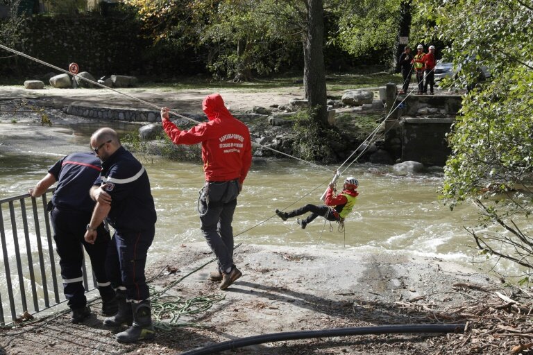 Des pompiers traversent un cours d'eau pour restaurer l'accès à l'eau potable après l'effondrement d'un pont détruit par la tempête Domingos, le 5 novembre 2023 à Corte, en Corse © Pascal POCHARD-CASABIANCA