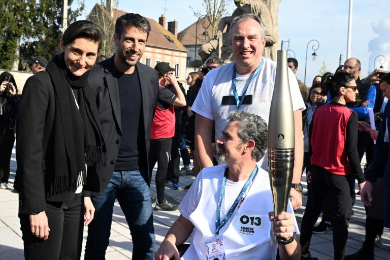 Le patron de Paris-2024 Tony Estanguet (2e g) et la ministre des Sports et des JO Amélie Oudéa-Castéra (g), lors du test relais de la flamme olympique à Nogent-sur-Seine, le 22 mars 2024  dans l'Aube © FRANCOIS NASCIMBENI