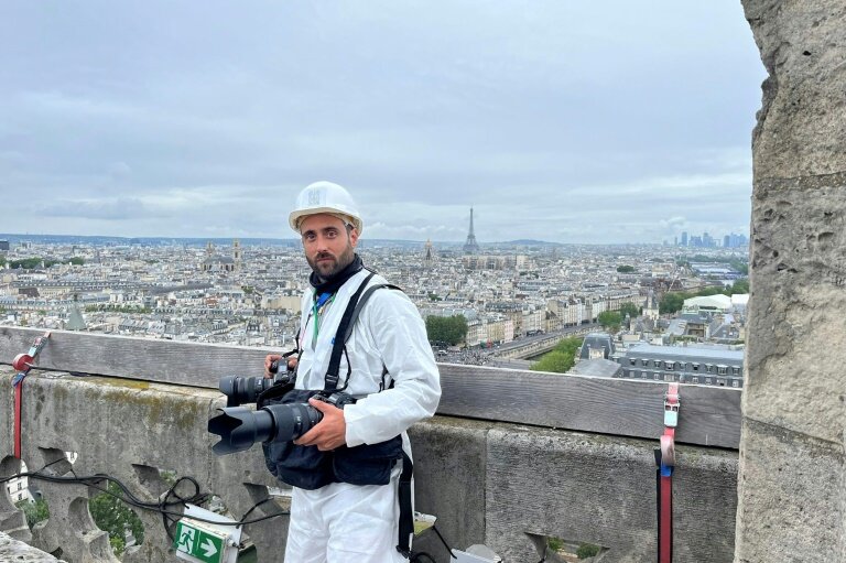 Le photographe de l'Agence France-Presse Julien De Rosa sur une tour de Notre-Dame avant la cérémonie d'ouverture des JO, le 26 juillet 2024 à Paris © -