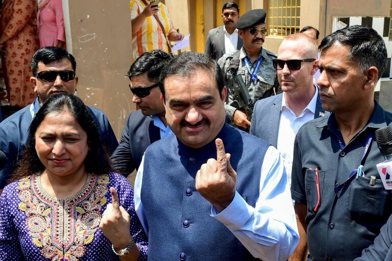 Le milliardaire indien Gautam Adani et son épouse Priti Adani montrent leurs index marqués à l'encre après avoir voté aux élections générales en Inde, le 7 mai 2024 à Ahmedabad, dans l'Etat du Gujarat © Sam PANTHAKY