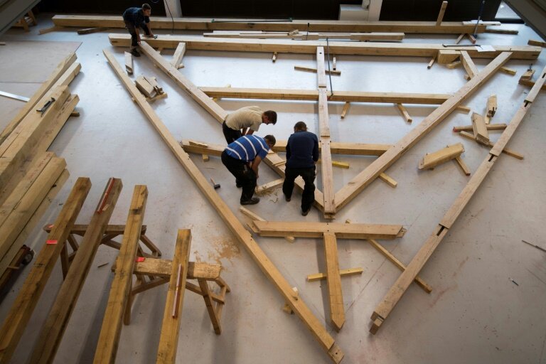 Des apprentis charpentiers travaillent sur une charpente correspondant à l'une des fermes de toit de la cathédrale Notre-Dame de Paris dans le cadre de leur formation chez les Compagnons du Devoir à Gennevilliers, le 3 octobre 2019 © Eric Feferberg