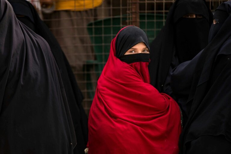 Une enfant attend devant une grille avec des femmes retenues dans le camp Al-Hol, dans le nord-est de la Syrie, où s'entassent des milliers de familles de combattants présumés du groupe Etat islamique, pour beaucoup étrangers, le 11 octobre 2023 © Delil SOULEIMAN