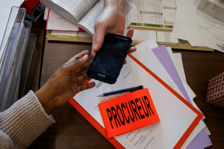 Un procureur remet à une femme un "téléphone grave danger" au palais de justice de Bobigny, le 15 janvier 2024 © Ludovic MARIN