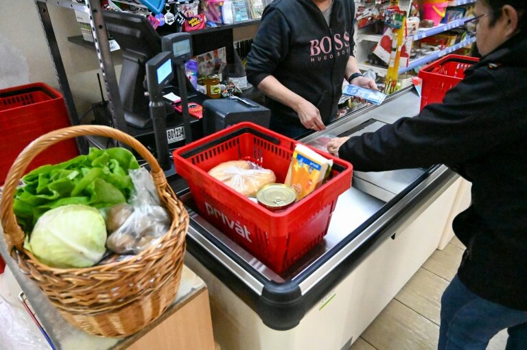 Un client à la caisse d'une épicerie du village hongrois de Tiszaroff, le 17 mars 2025 © ATTILA KISBENEDEK
