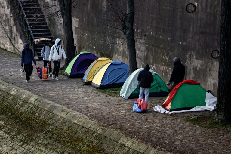 Des migrants évacués de la Gaîté Lyrique sont installés sur les quais de Seine à Paris le 28 mars 2025 © STEPHANE DE SAKUTIN