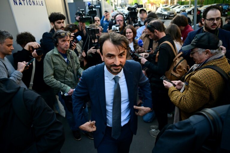 Le maire de Lyon, Grégory Doucet (C), sort après avoir été remis en liberté après plus de 10 heures d'interrogatoire dans le cadre d'une enquête pour détournement de fonds publics, à la préfecture de police de Lyon, le 9 avril 2025 © Olivier CHASSIGNOLE