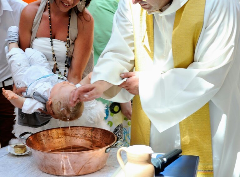 Un prêtre baptise un bébé dans une église de Tourcoing, dans le Nord, le 21 juillet 2013 © PHILIPPE HUGUEN