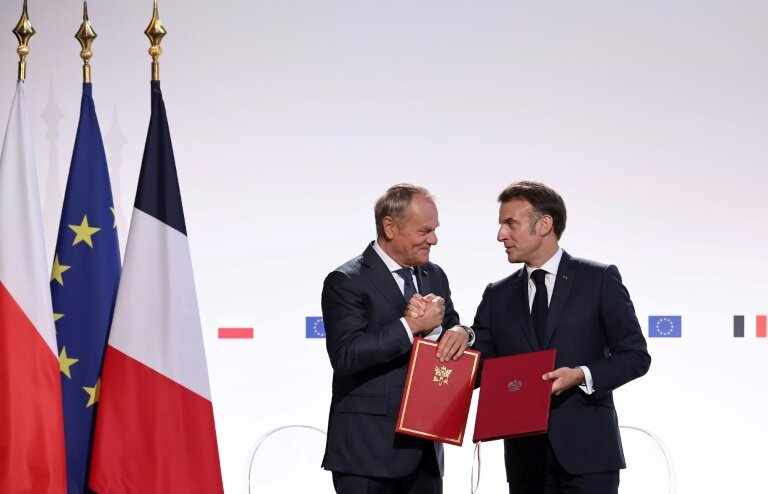 Le Premier ministre polonais Donald Tusk (g) et le président français Emmanuel Macron se serrent la main après avoir signé un traité à l'issue de leur rencontre à Nancy, le 9 mai 2025 © Christophe PETIT TESSON