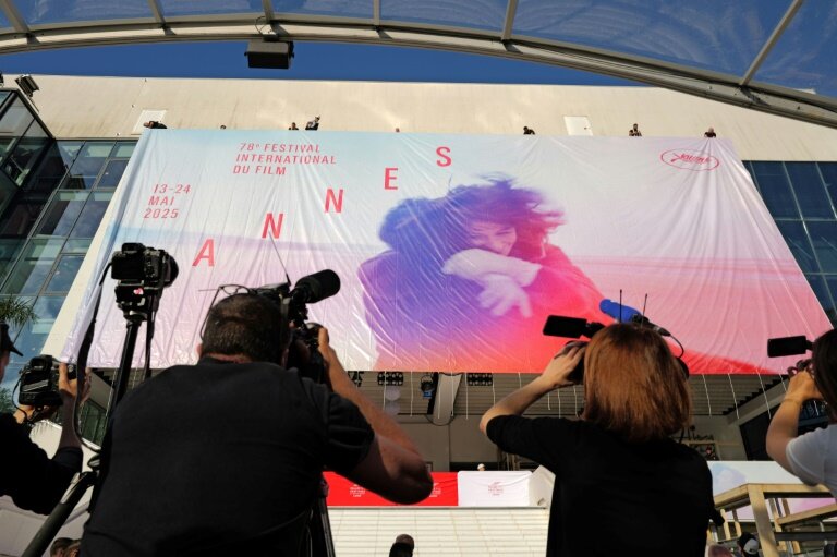 Des employés installent l'affiche officielle du 78e Festival de Cannes sur la façade du Palais des Festivals à Cannes, dans le sud-est de la France, le 11 mai 2025 © Valery HACHE
