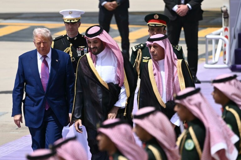 Le prince héritier saoudien Mohammed ben Salmane (c) accueille le président américain Donald Trump à son arrivée à Ryad, le 13 mai 2025 © Brendan SMIALOWSKI