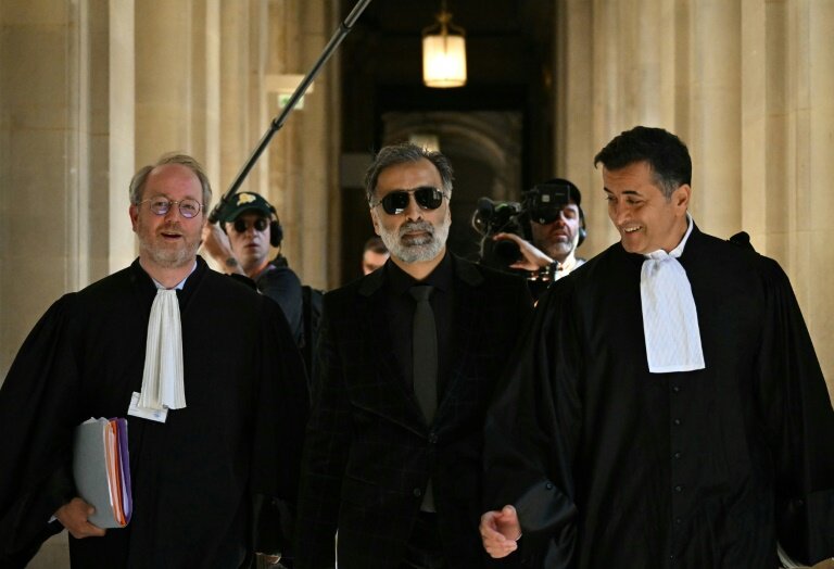 Le plaignant Abderrahmane Ouatiki (au centre), entouré de ses avocats, arrive au procès du braquage de Kim Kardashian, le 28 avril 2025 à Paris © Bertrand GUAY