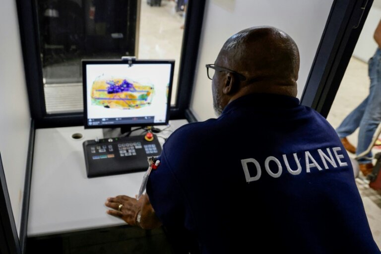 Un douanier français scanne le bagage d'un passager se rendant à Paris à l'aéroport international Félix-Eboué de Cayenne, le 24 mars 2024 © Ludovic MARIN