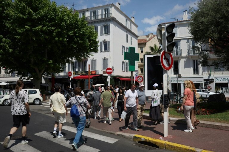 Des piétons dans une rue de Cannes où les feux tricolorent ne fonctionnent pas en raison d'une panne de courant, au dernier jour du 78e Festival de Cannes, le 24 mai 2025 dans les Alpes-Maritimes © Sameer AL-DOUMY