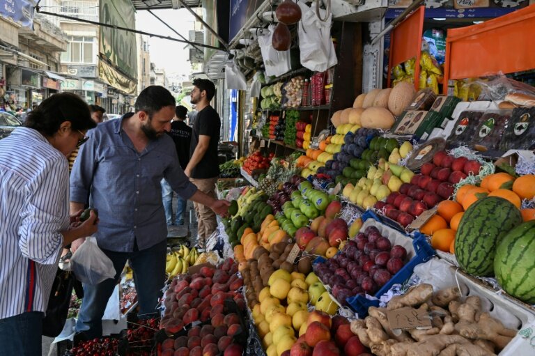 Un étal de fruits, dont des kiwis, des mangues et des ananas interdits à l'époque de Bachar al-Assad, dans une rue de Damas, le 26 mai 2025 en Syrie © LOUAI BESHARA