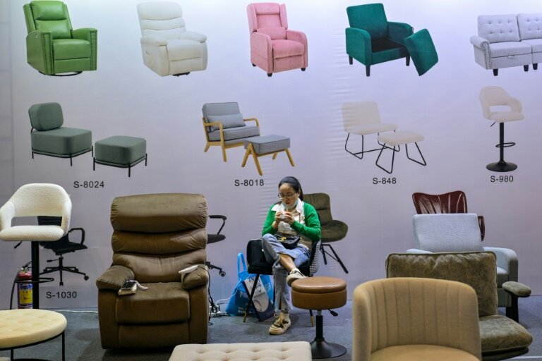 Une femme sur un stand de fauteuils lors de la foire-exposition à Ningbo, dans la province du Zhejiang, le 28 mai 2025 en Chine © Hector RETAMAL