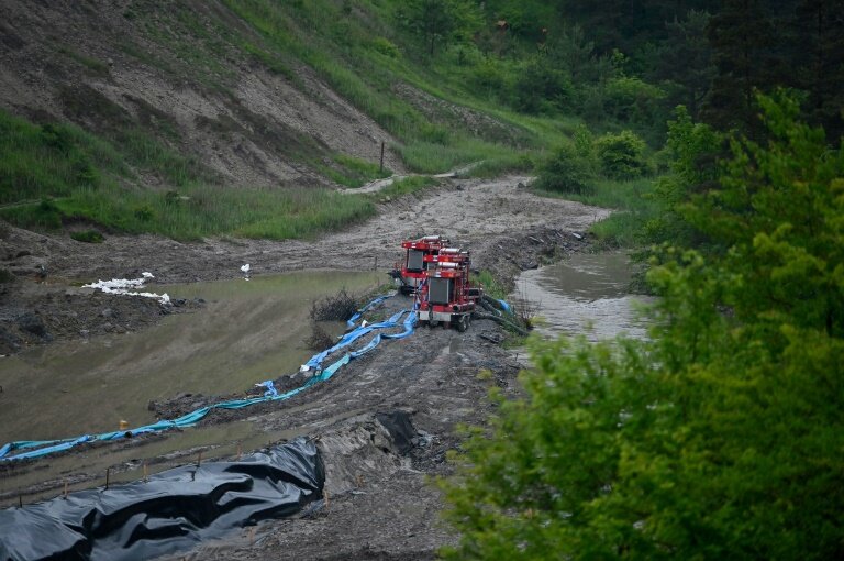 Des machines pompent de l'eau près de la mine de sel de Praid partiellement inondée par de fortes pluies, le 28 mai 2025 en Roumanie © Alex NICODIM