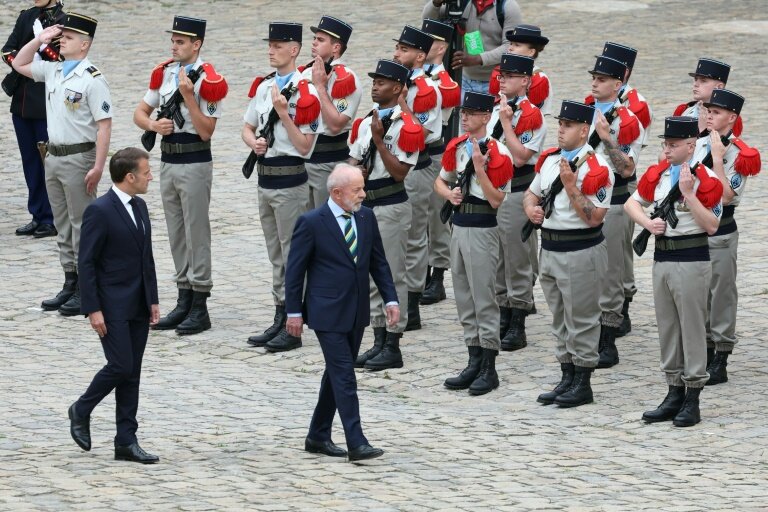 Le président français Emmanuel Macron (g) et son homologue brésilien Luiz Inácio Lula da Silva passent en revue la Garde d'honneur lors d'une cérémonie à l'hôtel des Invalides, le 5 juin 2025 à Paris © Thomas SAMSON