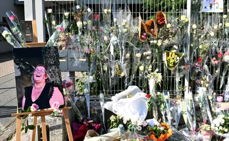 Une photo de Mélanie, la surveillante tuée par un élève, placée à côté des fleurs déposées devant les grilles du collège Françoise-Dolto, le 13 juin 2025 à Nogent, en Haute-Marne © FRANCOIS NASCIMBENI