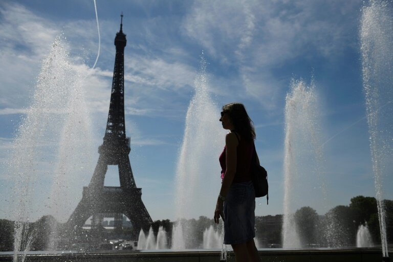 Une femme se rafraîchit près des fontaines du Trocadéro, lors de températures élevées à Paris, le 16 juin 2022 © JULIEN DE ROSA