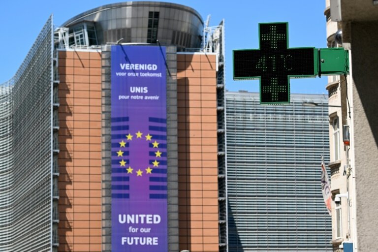 Un thermomètre de pharmacie affiche 41°C, avec en arrière-plan le siège de la Commission européenne, à Bruxelles, le 23 juin 2025 © Nicolas TUCAT