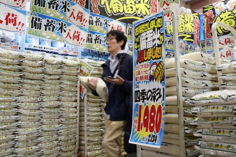Un client passe devant des sacs de riz vendus par la chaîne de magasins discount Don Quijote à Tokyo, le 1er juin 2025 © STR