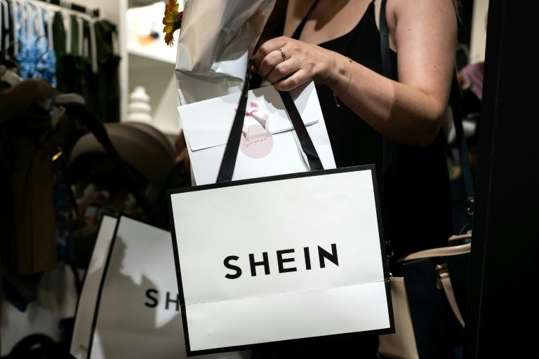 Une cliente à la sortie d'un magasin éphémère de la marque chinoise de fast fashion Shein à Dijon, le 26 juin 2025 © ARNAUD FINISTRE