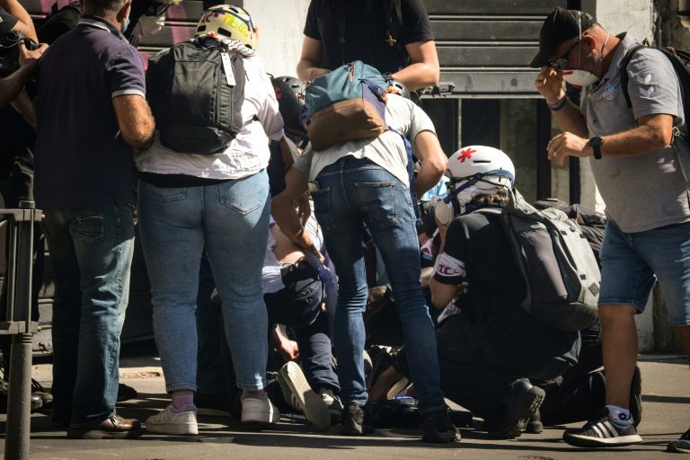 Un journaliste blessé de France TV (au centre en bas) est examiné par des secouristes lors de manifestations à Lyon, le 18 septembre 2025 © OLIVIER CHASSIGNOLE