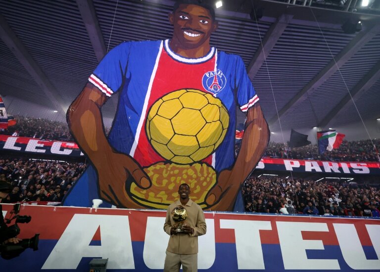 L'attaquant n°10 du Paris Saint-Germain Ousmane Dembélé et son trophée du Ballon d'Or lors d'une cérémonie après le match de football de L1 entre le Paris Saint-Germain (PSG) et Auxerre au stade du Parc des Princes à Paris, le 27 septembre 2025 © FRANCK FIFE
