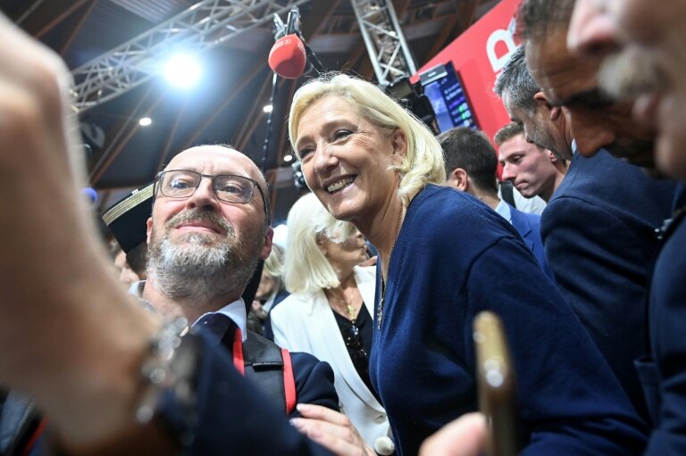 La cheffe de file du Rassemblement nationale, Marine Le Pen, fait un selfie avec un exposant lors du congrès des sapeurs-pompiers au Mans, le 10 octobre 2025 dans la Sarthe © JEAN-FRANCOIS MONIER