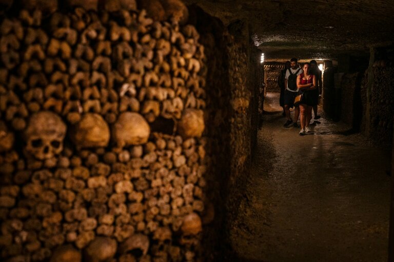 Des touristes visitent les catacombes de Paris, le 12 août 2025 © Dimitar DILKOFF