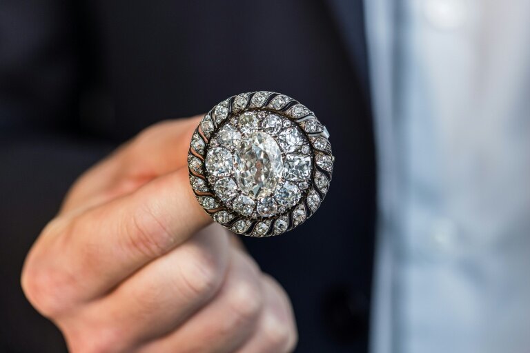 Un employé de Sotheby's présente une broche circulaire ornée de diamants anciens ayant appartenu à Napoléon Bonaparte et récupérée par l'armée prussienne après la défaite de Waterloo, avant une vente aux enchères à Genève, le 6 novembre 2025 © PIERRE ALBOUY