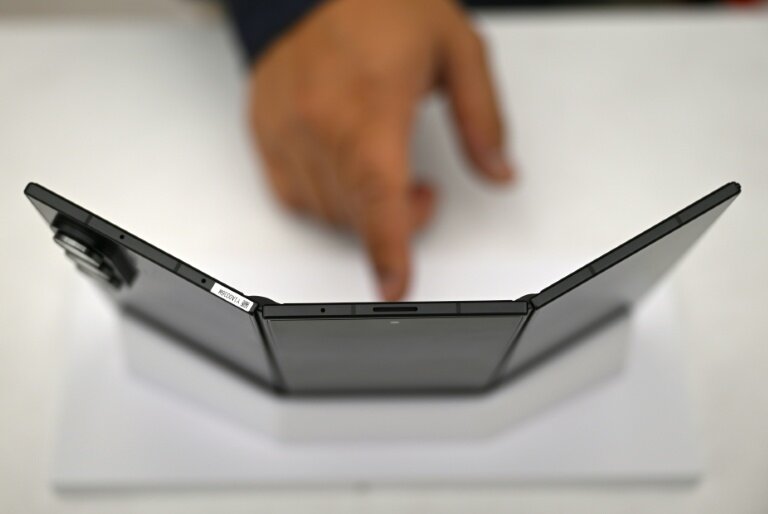 Un visiteur touche le Galaxy Z TriFold, un téléphone de Samsung pliable en trois, le 2 décembre 2025 à Séoul © Jung Yeon-je