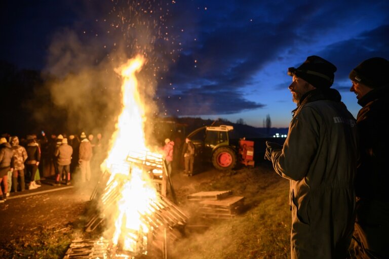 Des agriculteurs se réchauffent autour d'un feu, près de Léguevin (Haute-Garonne), le 7 janvier 2026 © Ed JONES