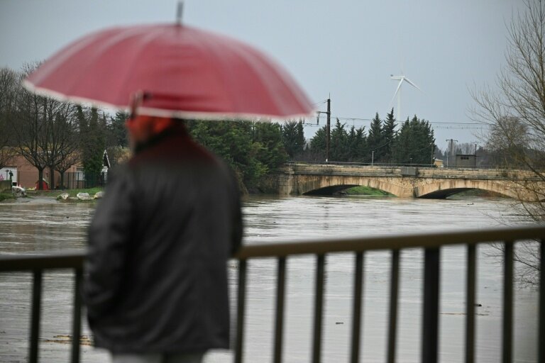 Un passant observe le débordement de l'Aude après des fortes pluies à Coursan, le 19 janvier 2026 dans l'Aude © Lionel BONAVENTURE