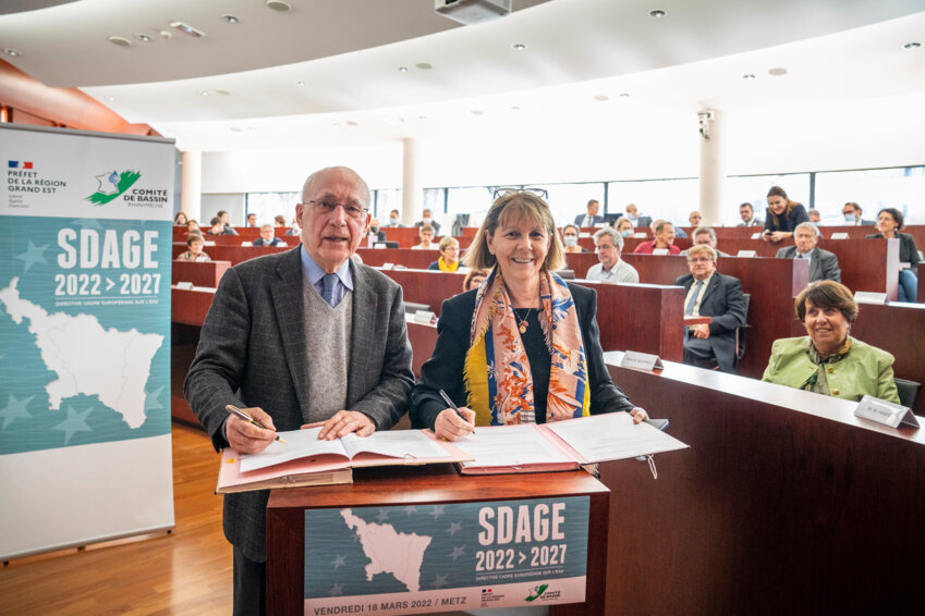 Claude Gaillard, président du Comité de bassin, et Josiane Chevallier, préfète de Région et préfète coordinatrice de bassin, signant l'arrêté d'approbation du plan de gestion des eaux du bassin Rhin-Meuse 2022-2027. © AERM/ N. Leblanc. 